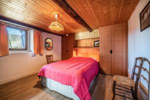 a bedroom with a bed and a wooden ceiling at Chalet authentique en vallée verte in Bogève