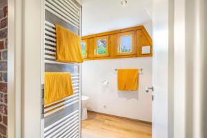 a bathroom with yellow towels and a toilet at Ferienhaus Eulennest in Billerbeck