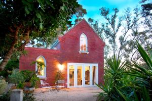 a red brick church with tables and chairs in front of it at be&be castlemaine in Castlemaine