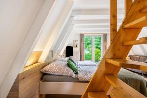 a bedroom with a bed and a wooden staircase at Ferienhaus Eulennest in Billerbeck