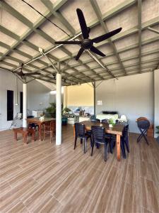 a living room with a ceiling fan and tables and chairs at Ummi Studio Homestay in Bayan Lepas