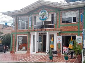a building with two umbrellas in front of it at Hotel La Palmita in Pacho