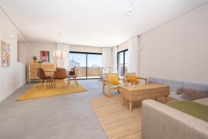 a living room with a couch and a dining room at Rivara Rooftop By ALGARTUR in Cabanas de Tavira