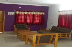 a room with couches and a table and red curtains at VS valley view resorts in Kotagiri