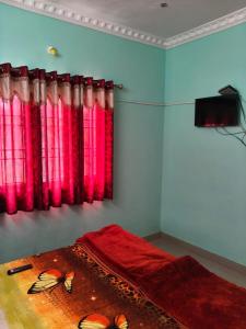 a bedroom with red and pink curtains and a bed at VS valley view resorts in Kotagiri