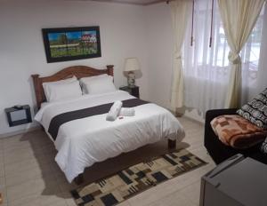 a bedroom with a bed with a teddy bear on it at Hotel La Palmita in Pacho