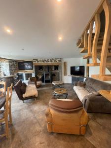 a large living room with couches and a staircase at Maison en Auvergne - Chez Julien et Stephy in Celles