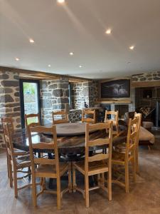 a dining room with a wooden table and chairs at Maison en Auvergne - Chez Julien et Stephy in Celles