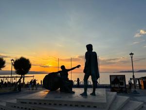 a statue of a man pointing at the sunset at Sisifou Apartment in Korinthos