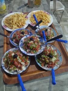 a table with plates of food and french fries at Gite Oussalem timichi in Timichchi