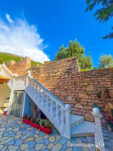 a white staircase with flowers in front of a brick wall at Kompleks Angjelo in Lukovë