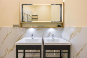 a bathroom with two sinks and a mirror at Partenope Rooms in Naples