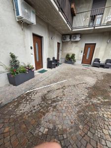 an empty courtyard of a building with chairs and plants at Malpensa Sleep & Go in Somma Lombardo