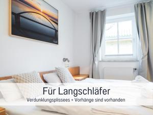 a hotel room with a bed and a window at Huus Binnensee - Erdgeschoss-Wohnung mit Garten & Seeblick - Wintergarten & Terrasse - hundefreundlich - ruhige Lage - Südstrand 5 Min mit Rad in Fehmarn