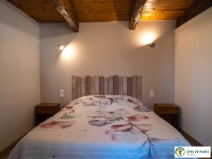 a bedroom with a bed with a floral bedspread at Gîte Le Cayrou in Saint-Just-sur-Viaur