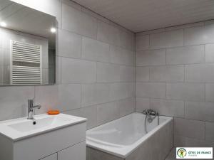 a white bathroom with a sink and a tub and a bath tubermott at Gîte Le Cayrou in Saint-Just-sur-Viaur +18 photos