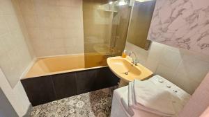 a bathroom with a sink and a tub and a toilet at Appart hôtel Roanne hyper centre ville in Roanne