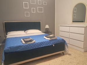 a bedroom with a bed with blue sheets and a dresser at Marina Serra in Marina Serra