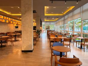 a restaurant with wooden tables and chairs and windows at ibis Canoas Shopping in Canoas