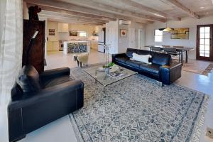 a living room with a black leather couch and a table at Five Ravens in Santa Fe