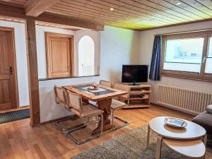 a living room with a table and a tv at Apartment 3 Bettwohnung by Interhome in Sils Maria
