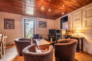 a room with chairs and a table and a kitchen at Chalet authentique en vallée verte in Bogève