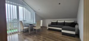 a bedroom with a bed and a table with chairs at Villa Rekin in Grzybowo