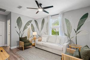 a living room with a white couch and a ceiling fan at The Cedar Loft B - Team Joseph Ellen in St. Augustine