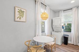 a dining room with a white table and a tv at The Cedar Loft B - Team Joseph Ellen in St. Augustine