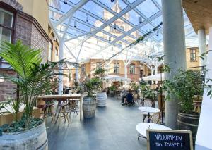 a conservatory with tables and plants in a building at U&Me; BW Signature Collection in Umeå