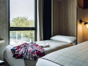 a hotel room with two beds and a window at ibis Styles La Rochelle Centre Gare in La Rochelle