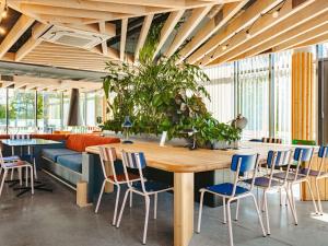 a dining room with a wooden table and chairs at ibis Styles La Rochelle Centre Gare in La Rochelle