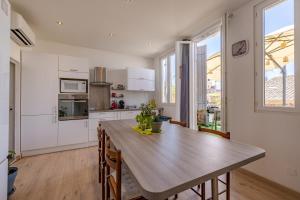 a kitchen and dining room with a wooden table at La Terrasse de Vidauban - Duplexe climatisé in Vidauban