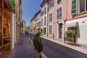 an empty city street with buildings and potted plants at La Terrasse de Vidauban - Duplexe climatisé in Vidauban