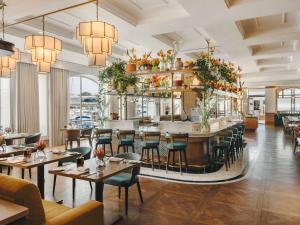 ein Restaurant mit Tischen und Stühlen und einer Bar in der Unterkunft Cape Grace, A Fairmont Managed Hotel in Kapstadt