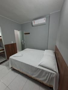 a bedroom with a bed with a white bedspread at Hotel e Pousada REQUINTTE in Parnaíba