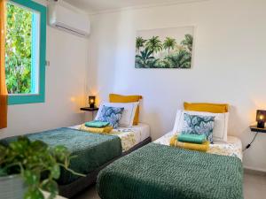 a room with two beds and a window at Espace Harmonie Deshaies - Vue Mer & Piscine Panoramique in Deshaies +107 photos