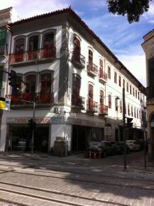 a white building on a street with cars parked in front at Hospedagem Ledo in Rio de Janeiro