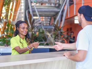 a woman standing at a counter talking to a man at Ibis Styles Mayotte Aéroport in Pamandzi +75 photos