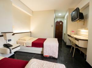 a hotel room with two beds and a sink at Hotel Camino Real Valera in Valera