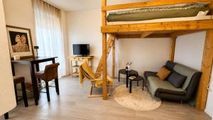 a living room with a couch and a bunk bed at Petit Canada - Studio à louer in Champex