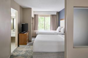 a hotel room with two beds and a television at SpringHill Suites by Marriott Atlanta Alpharetta in Alpharetta