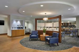 a lobby with chairs and a bar in the background at SpringHill Suites by Marriott Atlanta Alpharetta in Alpharetta