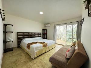 a bedroom with a bed and a couch and a window at The Rock House Eco in San Andrés