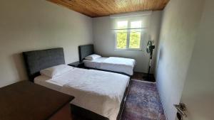 two beds in a small room with a window at Umut Konaklama in Ardeşen