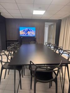 a conference room with a table and chairs and a tv at La Gioconda Apart Hotel in Villa María +57 photos