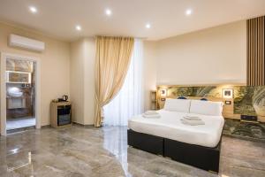 a bedroom with a large white bed and a window at Partenope Rooms in Naples