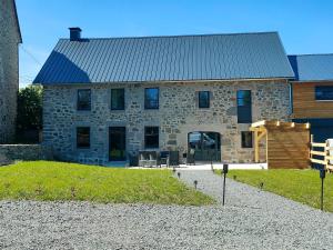 a stone house with a blue roof and a yard at Maison en Auvergne - Chez Julien et Stephy in Celles