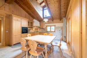 a wooden kitchen with a wooden table and chairs at Ciesa Al Drago in Rocca Pietore +28 photos