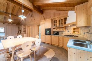 a large kitchen with a wooden table and chairs at Ciesa Al Drago in Rocca Pietore